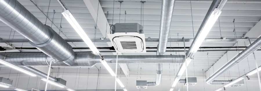 A commercial hall with a ventilation system, ceiling mounted cassette type air condition units, and ducts.